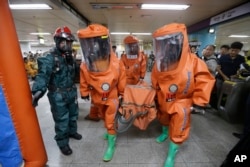 South Korean firefighters wearing protective gears move during an anti-terror drill as part of Ulchi Freedom Guardian exercise, at Yoido Subway Station in Seoul, South Korea, Aug. 23, 2016.