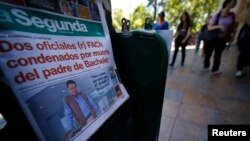 An afternoon edition of the "La Segunda" newspaper, with its front page headline reading "Two Air Force officers convicted of killing the father of Bachelet," the latter referring to Chilean President Michelle Bachelet, is seen at a stand in downtown Santiago, Nov. 21, 2014. 
