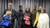 FILE - The families of missing British girls Amira Abase and Shamima Begum pose for a picture after being interviewed by the media in central London, Feb. 22, 2015. 