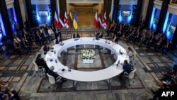 Georgian President Giorgi Margvelashvili (4-R), Polish Foreign Minister Jacek Czaputowicz (3-L), Lithuania's Foreign Minister Linas Linkevicius (L), Latvia's Foreign Minister Edgars Rinkevics (2-L) and other officials attend a round table meeting in Tbilisi, Georgia, Aug. 7, 2018, a day ahead of the 10th anniversary of the start of the brief war between Russia and Georgia over control of South Ossetia.