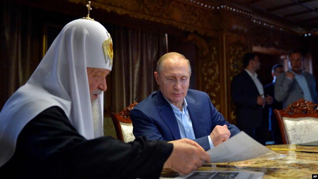 Russian President Vladimir Putin, with Russian Orthodox Patriarch Kirill, left, speak in the library of the Russian monastery St. Panteleimon at Karyes, on Mount Athos, Greece, May 28, 2016.