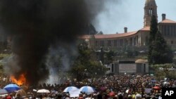 Des étudiants brûlent des toilettes portables au cours des manifestations contre la hausse des frais de scolarité à Pretoria, Afrique du Sud, 23 octobre 2015. (AP Photo/Themba Hadebe)