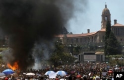 FILE - Students burn portable toilets during their protest against university tuition hikes outside the union building in Pretoria, South Africa, October 23, 2015.