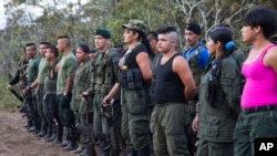 FILE - Rebels of the Revolutionary Armed FOrces of Colombia, FARC, stand on formation at their camp next to the site where is the group is holding it's 10th conference in the Yari Plains, Colombia, Sept. 17, 2016. 