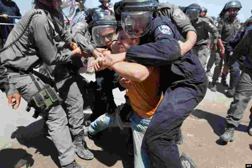 An Israeli settler is arrested by security forces as demolition begins of the so-called Dreinoff buildings under an Israeli High Court ruling in the settlement of Beit El, north of Ramallah in the occupied West Bank. 