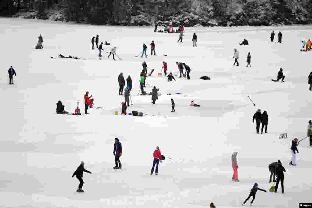 People ice-skate and play hockey on the frozen lake Spitzingsee as stricter lockdown measures are in place to contain the spread of the coronavirus disease (COVID-19) near the resort town of Schliersee, Germany.