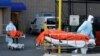 Des travailleurs de la santé font rouler les corps de personnes décédées du Wyckoff Heights Medical Center lors de l'éclosion de la maladie à coronavirus (COVID-19) dans le quartier de Brooklyn à New York, New York, États-Unis, le 4 avril 2020. REUTERS / Andrew Kelly