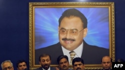 Leader of the Pakistani political party Muttahida Qaumi Movement (MQM), Farooq Sattar (3rd L), announces his parties decision to quit the coalition government in front of the portrait of MQM's self-exiled chief Altaf Hussain during a press conference in Karachi, June 27, 2011.