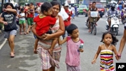Residents rush to higher grounds following tsunami rumors due to a magnitude 6.9 earthquake which hit the island province of Cebu and other central Philippine provinces, February 6, 2012.