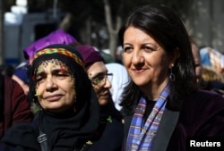 FILE - Pervin Buldan, right, a co-leader of Turkey's main pro-Kurdish Peoples' Democratic Party (HDP), poses with a supporter during a Women's Day rally in Istanbul, Turkey, March 4, 2018.