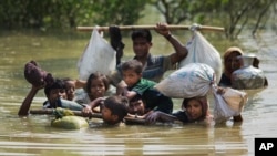 A Rohingya family reaches the Bangladesh border after crossing a creek of the Naf river on the border with Myanmmar, in Cox's Bazar's Teknaf area, Sept. 5, 2017.