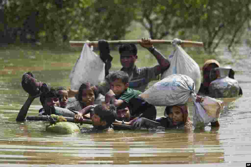 A Rohingya family reaches the Bangladesh border after crossing a creek of the Naf river on the border with Myanmmar, in Cox&#39;s Bazar&#39;s Teknaf area.