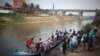 Burmese migrants, illegal workers use boat to cross Moei River bordering town of Myawaddy, Burma, visible in the background, to Mae Sot, Thailand, March 21, 2012.