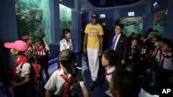 FILE - Former NBA basketball star Dennis Rodman walks with school children during his visit to Pyongyang's Central Zoo, June 16, 2017.