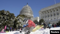 FILE - A boy crashes his sled on a hill at the U.S. Capitol after a major winter storm swept over Washington, Jan. 24, 2016.