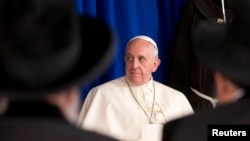 Pope Francis listens to a speech as he meets Israel's Rabies David Lau and Yitzhak Yosef in Jerusalem, May 26, 2014. 