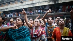 Garment workers shout as they call on other workers to join them during a protest in Dhaka, Sept. 23, 2013.