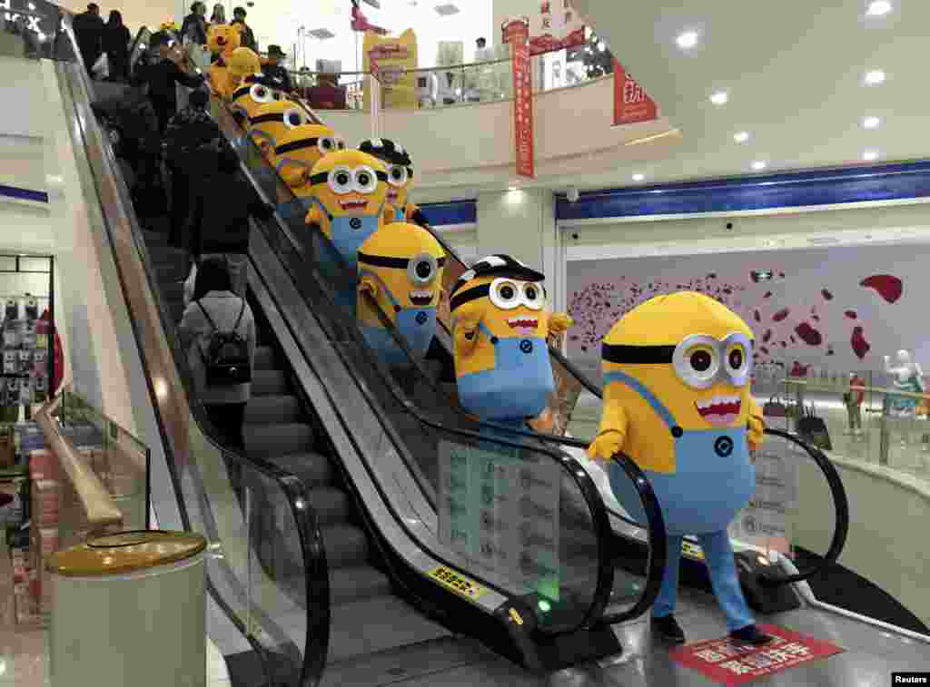 Mengenakan kostum karakter minion dari film &quot;Minions&quot;, sejumlah orang menuruni eskalator sebagai bagian dari promosi film itu di sebuah mall di Wuhan, propinsi Hubei, China, tanggal 14 November 2015.