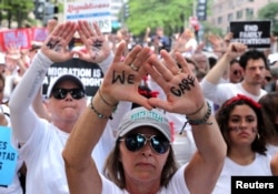 FILE - Immigration activists rally as part of a march calling for "an end to family detention" and in opposition to the immigration policies of the Trump administration, in Washington, June 28, 2018.