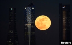 A supermoon rises in between four towers in a skyscrapers area in Madrid, Spain, Jan. 31, 2018.
