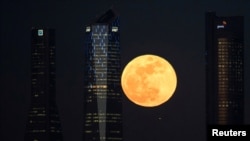 A full moon "supermoon" rises in between four towers in a skyscrapers area in Madrid, Spain, January 31, 2018. 