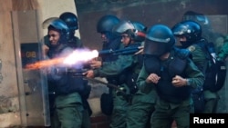 FILE - A riot security force member fires his weapon at a rally during a strike called to protest against Venezuelan President Nicolas Maduro's government in Caracas, Venezuela July 26, 2017.