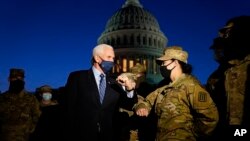 Wapres AS Mike Pence menyalami seorang anggota Garda Nasional dengan sikunya, saat meninjau pasukan yang berjaga di luar gedung Capitol, Washington, D.C., Kamis, 14 Januari 2021(Foto AP / Alex Brandon, Pool)
