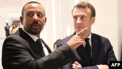 Ethiopian Prime Minister Abiy Ahmed (L) speaks with French President Emmanuel Macron (R) before a meeting in Addis Ababa, March 12, 2019.