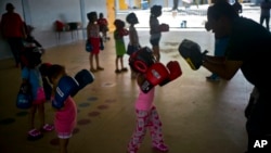 In this Friday, Oct. 13, 2017 photo, children learn to box at a school-turned-shelter for residents left homeless by Hurricane Maria in Toa Baja, Puerto Rico.(AP Photo/Ramon Espinosa)