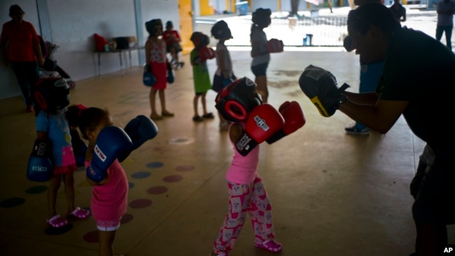 In this Friday, Oct. 13, 2017 photo, children learn to box at a school-turned-shelter for residents left homeless by Hurricane Maria in Toa Baja, Puerto Rico.(AP Photo/Ramon Espinosa)