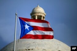 The Puerto Rican flag flies in front of Puerto Rico's Capitol in San Juan