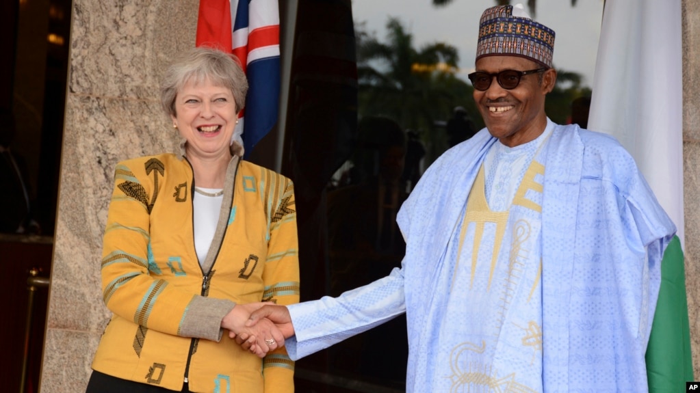 British Prime Minister Theresa May, left, is welcomed by Nigeria's President Muhammadu Buhari, at the Presidential palace in Abuja, Nigeria, Aug. 29, 2018.