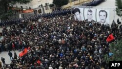 Family members, opposition Socialist leaders and supporters lay flowers during an anti-government protest in the Albanian capital Tirana Friday, Jan. 28, 2011 to honor three opposition supporters, pictured top right, shot dead during a protest last week.