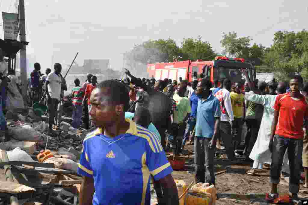 Mutane sun taru kusa da inda bam ya tashi cikin mota a kasuwar &quot;Monday Market&quot; ta Maiduguri, talata 1 Yuli, 2014. Mutane da dama sun mutu, akasarinsu mata tsoffi da almajirai dake bara.