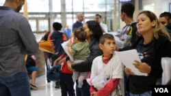 Các di dân có con nhỏ đang chờ đợi được nhập cảnh hợp pháp vào Mỹ ở McAllen, bang Texas