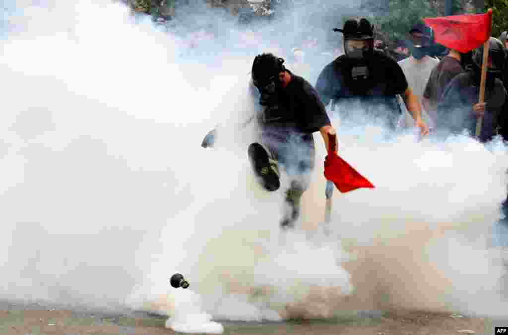 June 15: A demonstrator kicks a tear gas canister outside the Parliament in central Athens, during a rally against plans for new austerity measures.