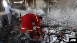 Les pompiers libyens éteignent un incendie dans un entrepôt utilisé à Ajdabiya, dans l'est du pays, le 5 juillet 2012.