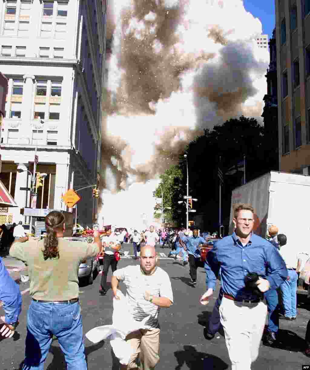 (FILE) Pedestrians run from the scene as one of the World Trade Center Towers collapses 11 September, 2001 in New York following a terrorist plane crash on the twin towers. AFP PHOTO Doug KANTER (Photo by DOUG KANTER / AFP)