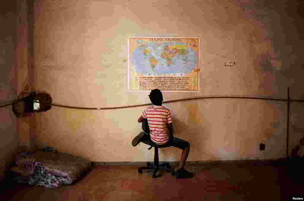 Wellington, 11, a relative of a member of Brazil's Movimento dos Sem-Teto (Roofless Movement), looks at a world map in a vacant apartment during the occupation of an empty building in downtown Sao Paulo.