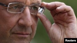 France's President Francois Hollande adjusts his glasses after a meeting at the Elysee Palace in Paris, September 20, 2012.