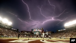 After an hour long weather delay, a lightning strike occurs as Texas State warms up in Doak Campbell Stadium prior to an NCAA college football game against Florida State in Tallahassee, Fla., Saturday, Sept. 5, 2015. (AP Photo/Mark Wallheiser)