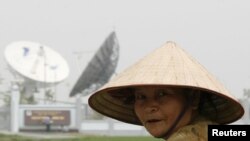 ຊາວນາຫວຽດນາມຄົນນຶ່ງ ຂີ່ລົດຖີບ ຜ່ານສູນກາງຄວບຄຸມ ດາວທຽມ ຂອງຫວຽດນາມ ຢູ່ບ້ານ Que Duong, ນອກນະຄອນຫລວງຮາໂນ່ຍ.