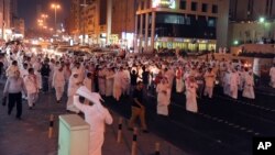 Kuwaiti men walk down Fahed Al Salem Street during a demonstration in Kuwait City on Sunday, October 21, 2012.