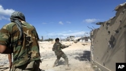 Anti-Gadhafi fighters return fire during clashes with pro-Gadhafi forces in the center of Sirte October 17, 2011.