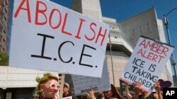 Manifestantes portan carteles durante un acto frente a la oficina del Servicio de Inmigración y Aduanas, ICE, en Los Ángeles, California, el lunes, 2 de julio de 2018.