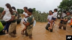 India army soldiers carry children rescued from flood-affected villages near Thara in Banaskantha district, Gujarat, India, July 26, 2017.