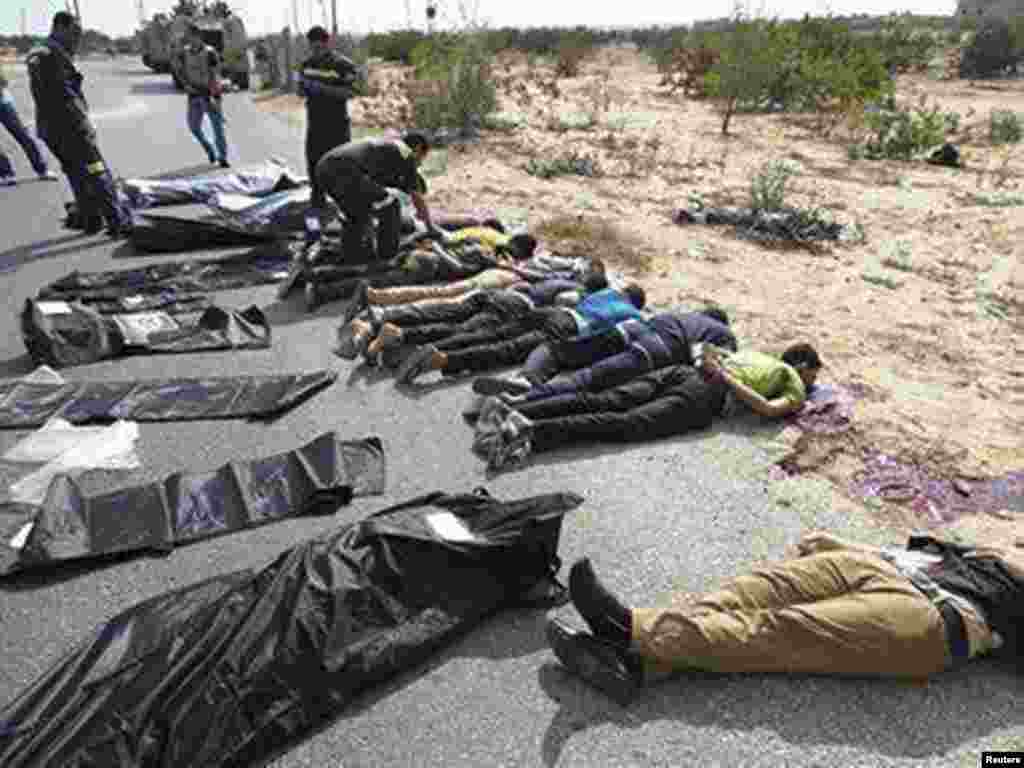 Soldiers and medical workers check the bodies of police officers killed on a highway in Rafah city, about 350 kilometers northeast of Cairo, August 19, 2013.