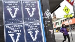 A person walks past posters encouraging people to get vaccinated in Melbourne on Aug. 31, 2021 as the city experiences it's sixth lockdown as it battles an outbreak of the Delta variant of coronavirus.