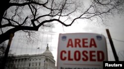 Siyn "Ara Closed" oubyen "Zòn sa a Fèmen" te devan Kongrè ameriken an nan dat 22 janvye 2018, swa 3èm jou fèmti gouvènman federal la nan kòmansman ane a.
U.S. Capitol building is seen during the third day of a government shutdown in Washington