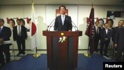 Japan's Prime Minister and the leader of the ruling Liberal Democratic Party (LDP), Shinzo Abe (C) makes an appearance before the media at a news conference following a victory in the upper house elections by his ruling coalition, at the LDP headquarters 